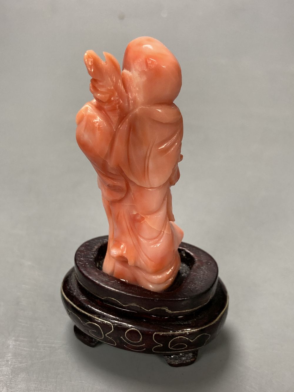 A Chinese carved coral figure of Shou Lao, on inlaid wooden stand, overall 81mm.